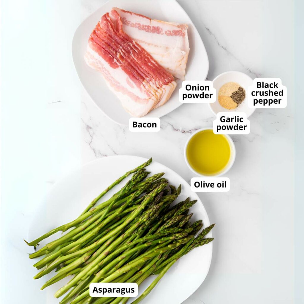 Ingredients for a bacon wrapped asparagus laid out on a marble surface.