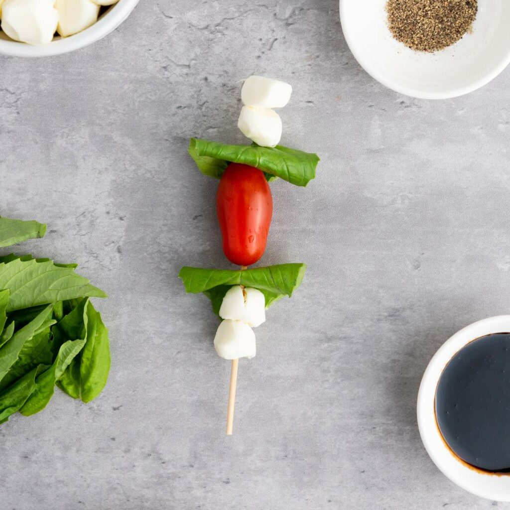 Skewer with mozzarella, basil, and a cherry tomato.