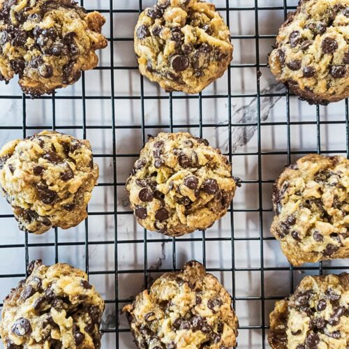 Keto magic cookies cooling on a black wire rack placed on a white marble surface.