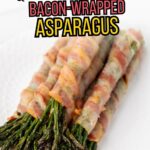 A plate with several bundles of asparagus spears wrapped in cooked bacon, arranged neatly on a white surface.
