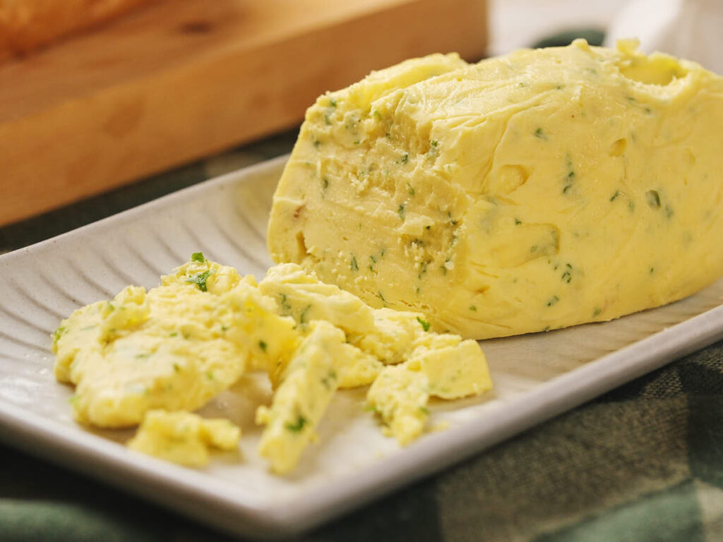 Roasted garlic butter with a textured surface sits on a rectangular plate.