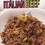 A white bowl filled with shredded Italian beef topped with sliced green peppers, with a fork lifting some meat.