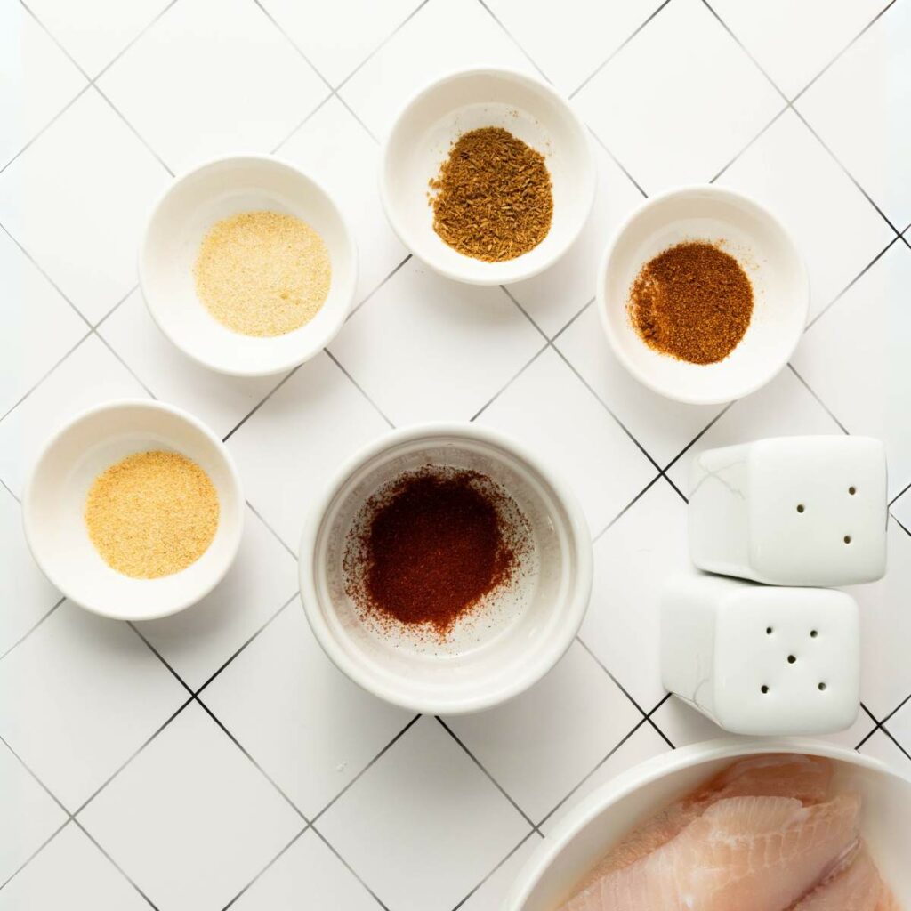 Five small bowls with assorted spices.