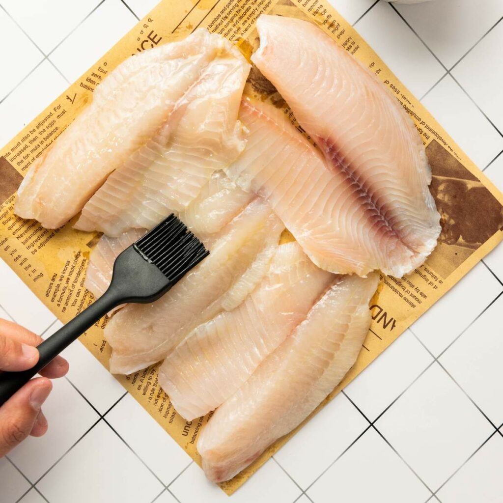 Four raw fish fillets are laid on brown paper.