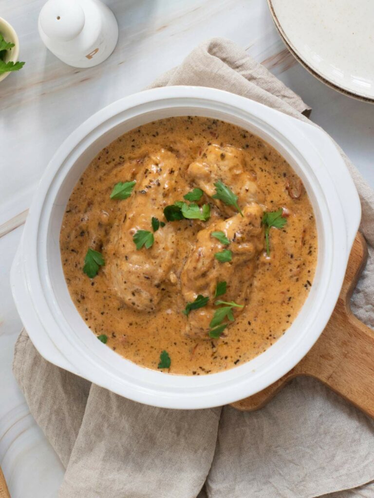 Creamy herb-seasoned marry me chicken garnished with fresh parsley.