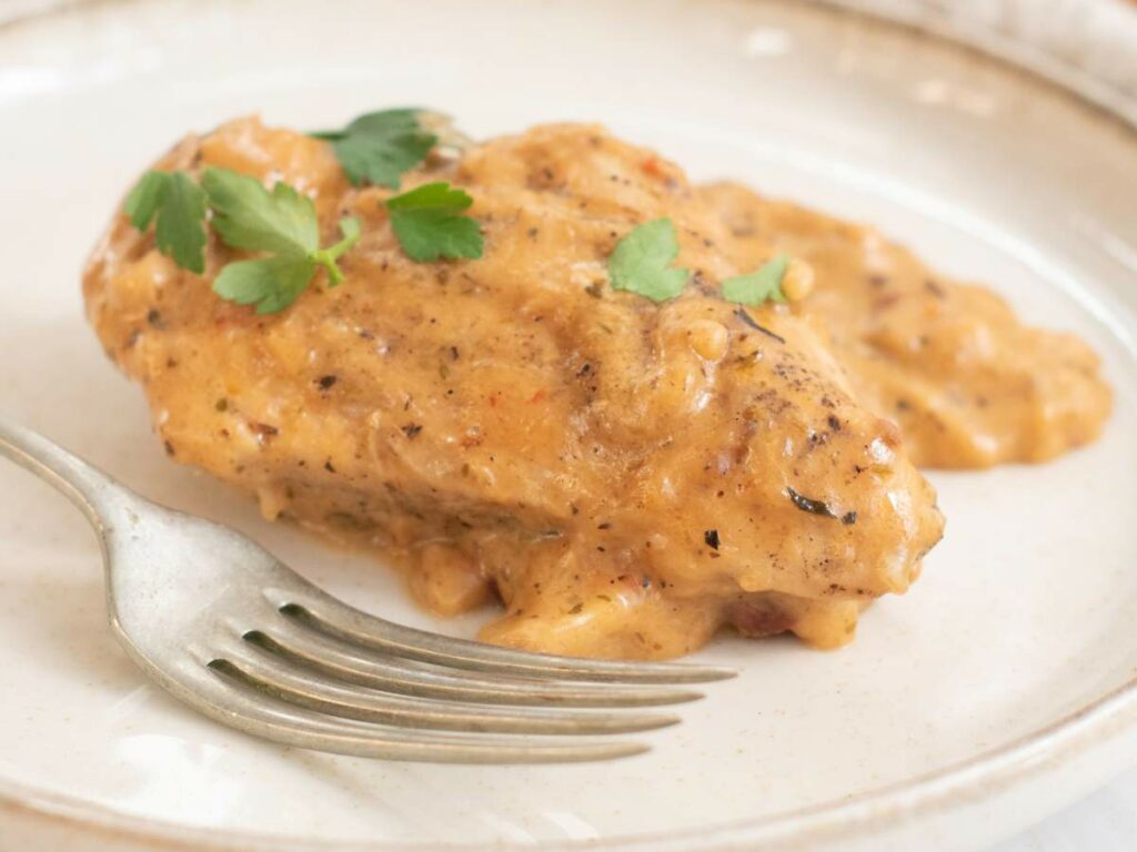 A piece of chicken breast covered in creamy sauce.