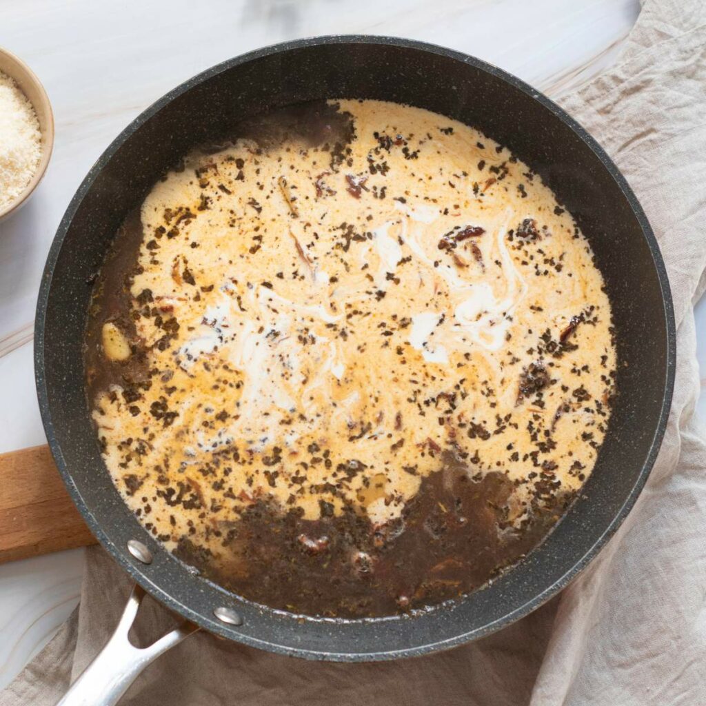 A skillet with a creamy sauce and visible browned bits.