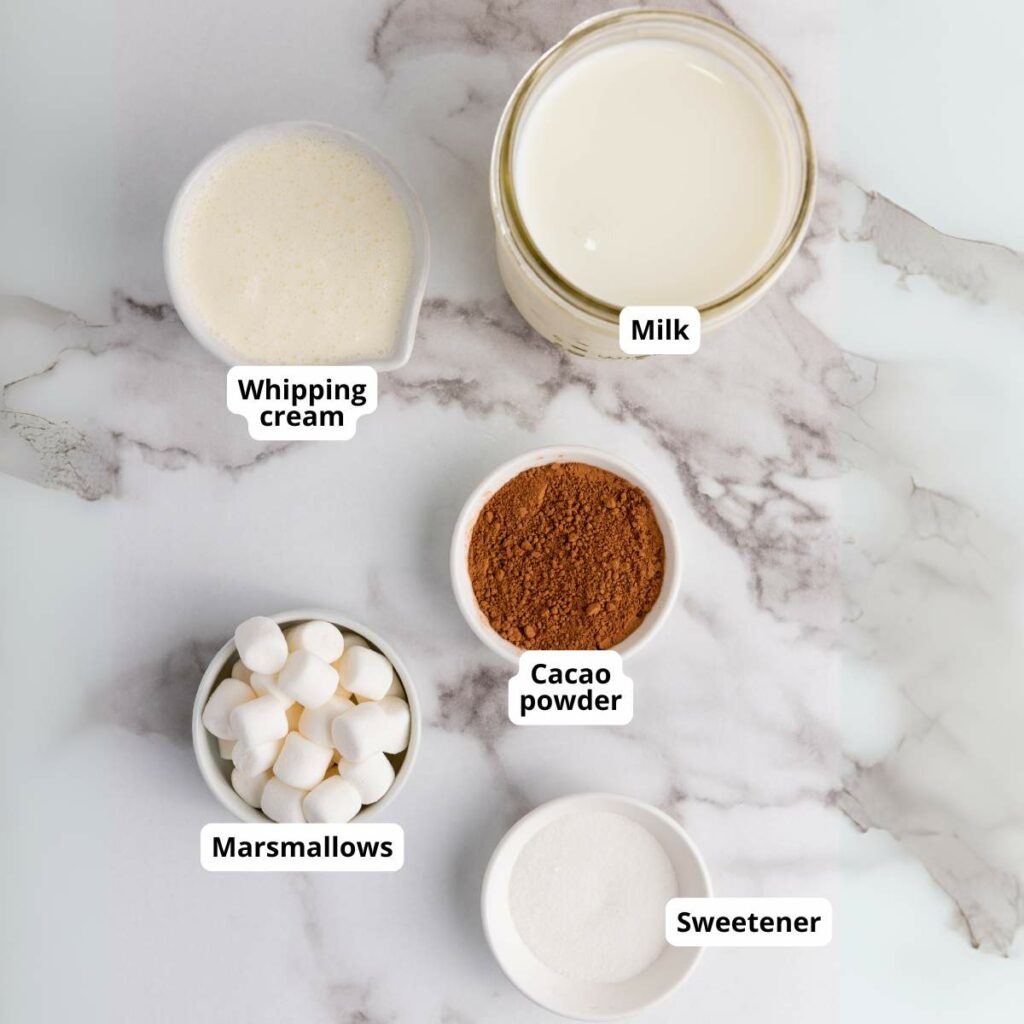 Top-view of labeled ingredients for chocolate milk on a marble surface.