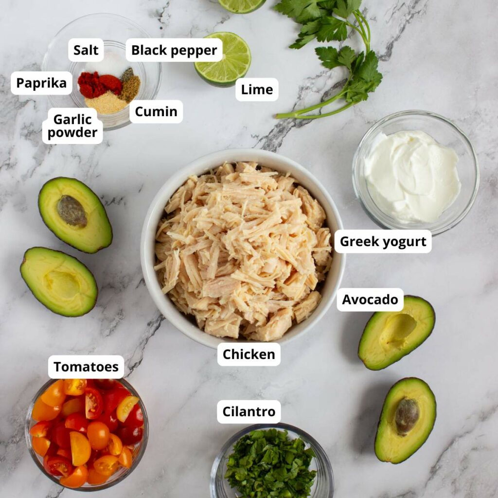 A bowl of shredded chicken surrounded by labeled ingredients.