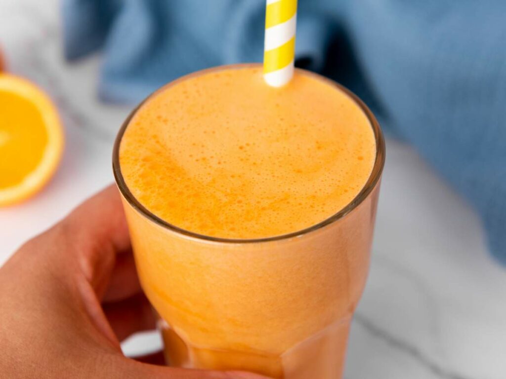 A immunity boost juice with a yellow and white striped straw.
