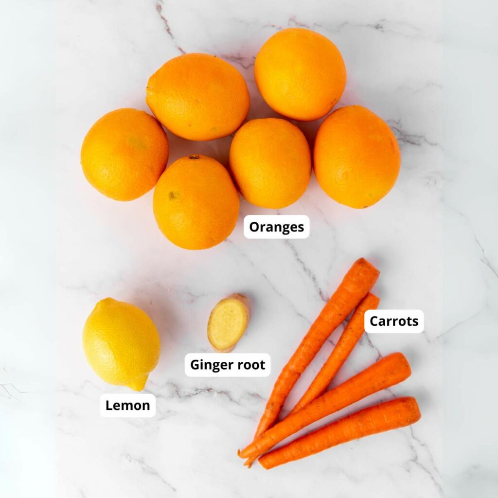 A group of oranges, a lemon, a piece of ginger root, and three carrot.