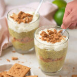 Two servings of key lime chia pudding ona white surface.