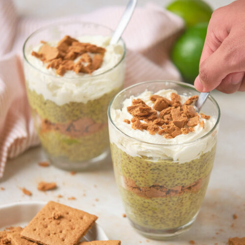 Two servings of key lime chia pudding ona white surface.