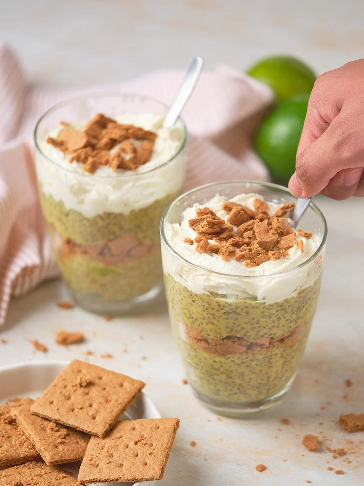 Two servings of key lime chia pudding ona white surface.