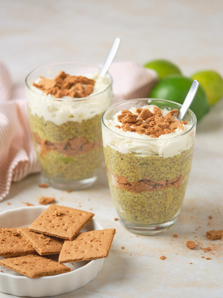 Key lime chia puding in two glasses served topped with crackers.