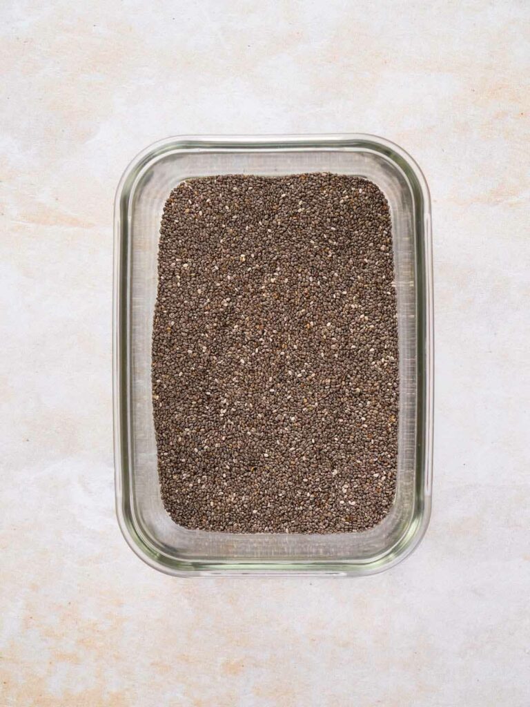 Chia seeds in a transparent glass dish.