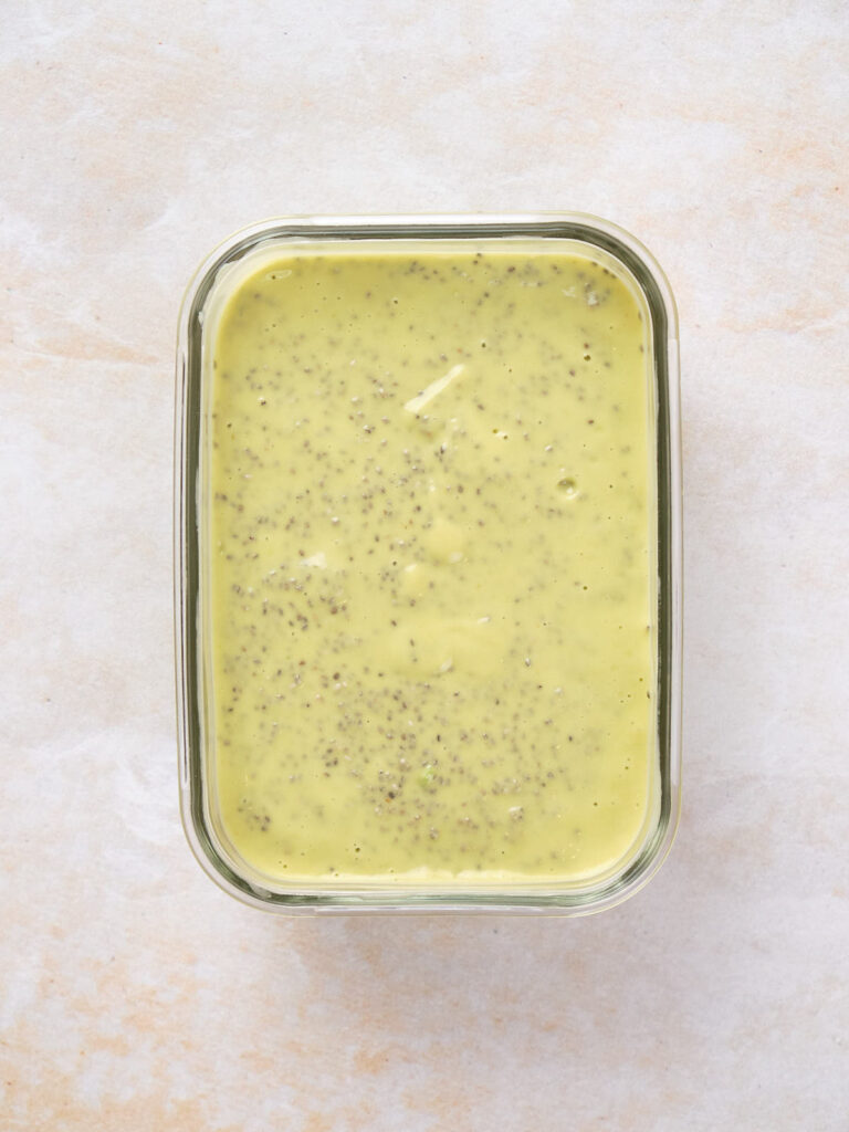 An avocado mixture over chia seeds in a glass dish.