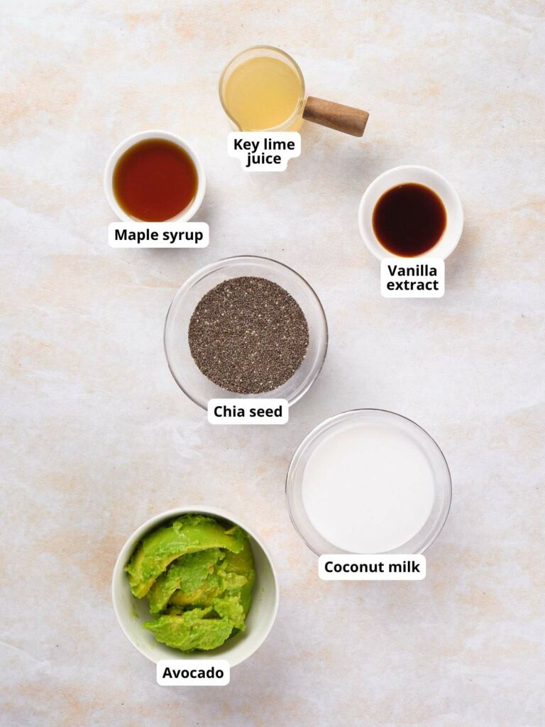 Ingredients for key lime chia pudding laid out on a white surface, each labeled.