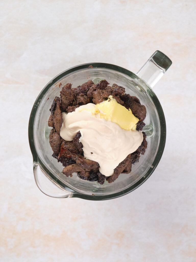 Cream and butter on top of beef liver inside a blender.