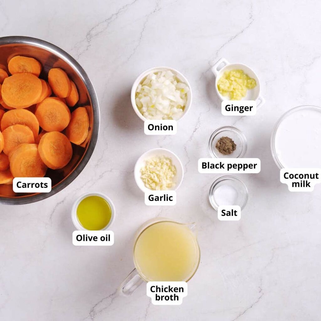 Various soup ingredients for carrot and ginger soup with coconut milk shown in separate bowls and cups.