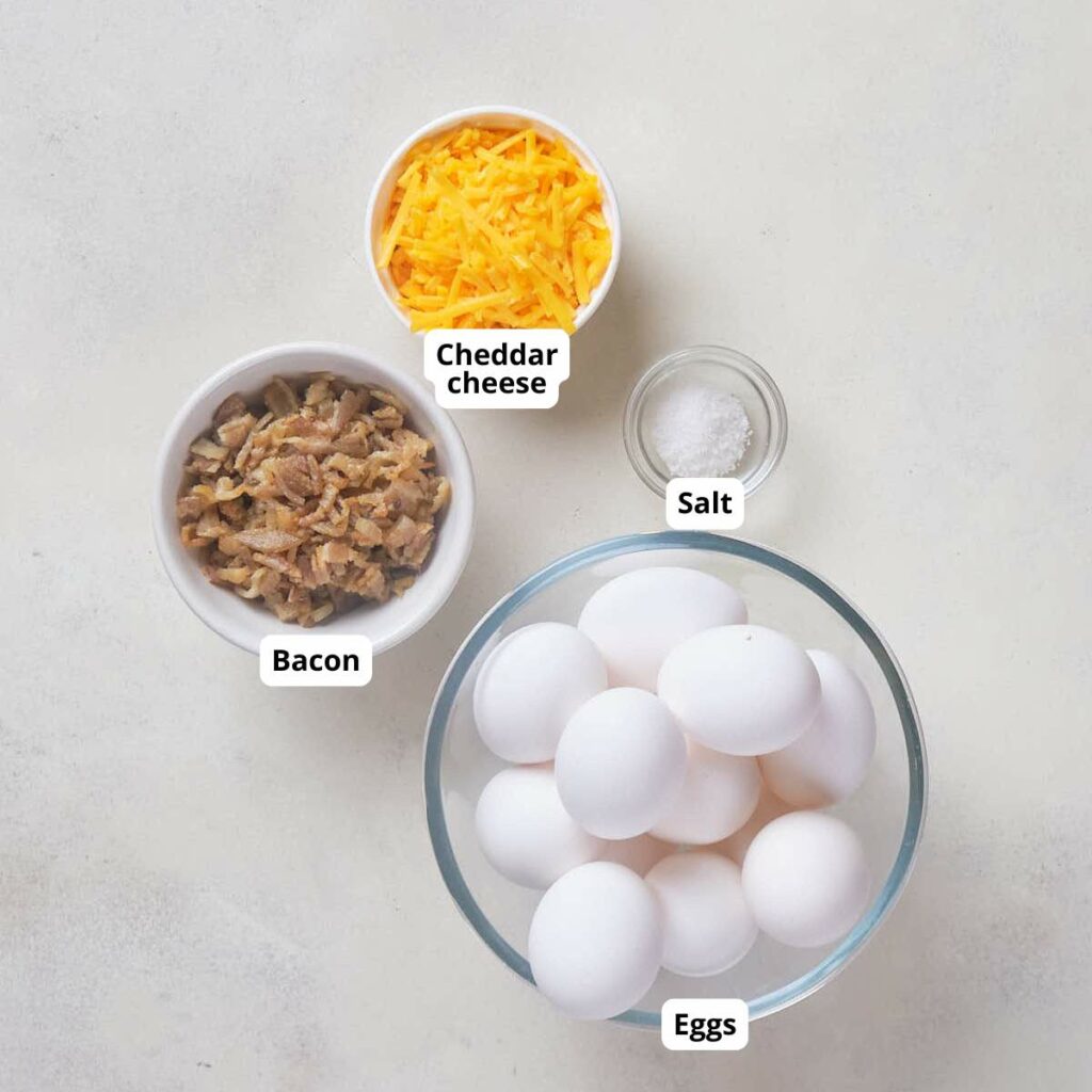 Ingredients for bacon cheddar egg muffins recipe are arranged on a light surface.