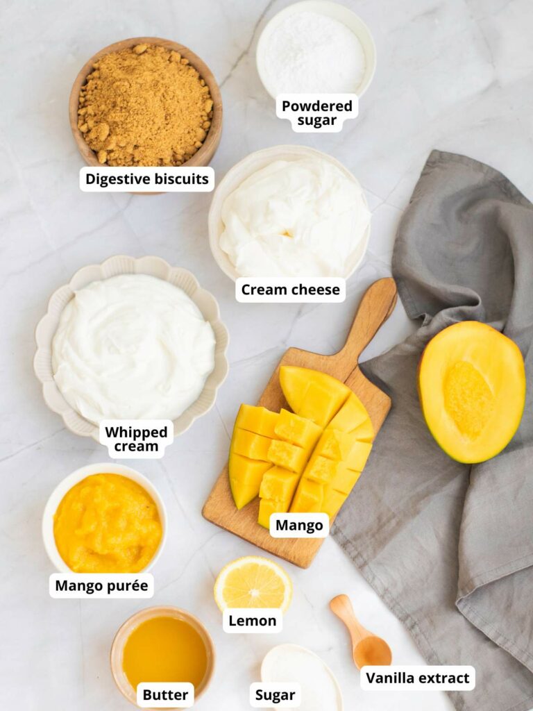 Ingredients for a mango cheesecake are laid out on a table.