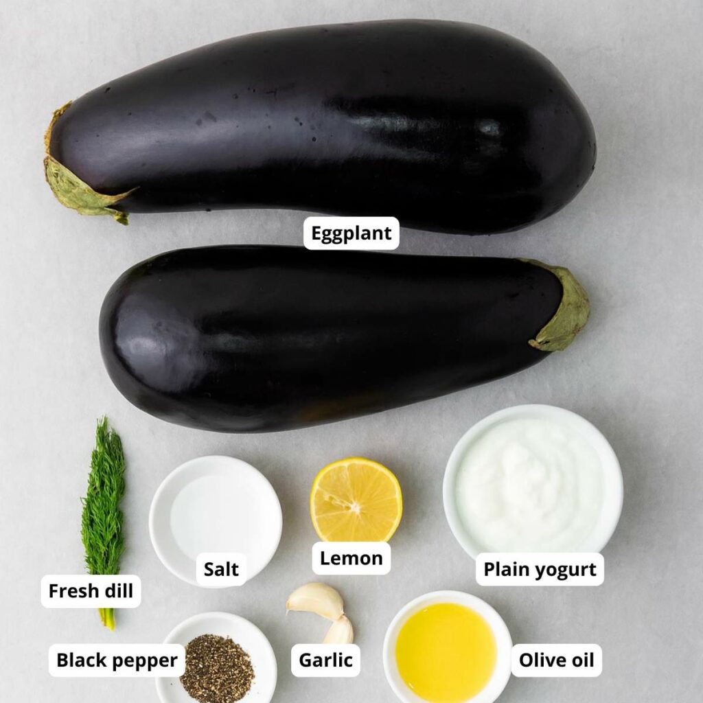 Ingredients for roasted eggplant arranged on a light surface.