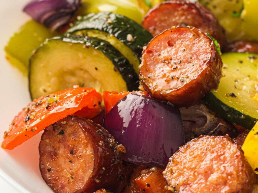 A colorful mix of sausage, zucchini, peppers, and red onion glistens with seasoning.