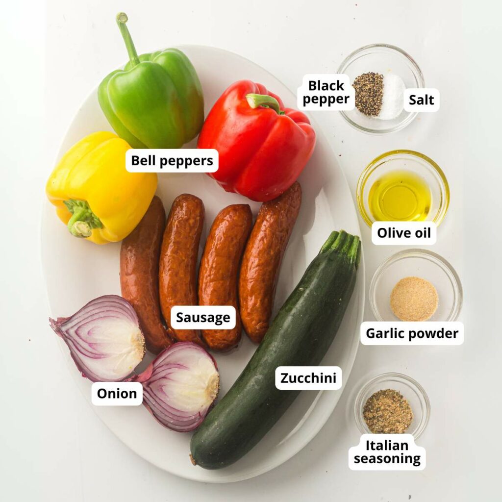 All ingredients for the dish, are displayed and labeled on a white plate and spices in a small glass bowl.
