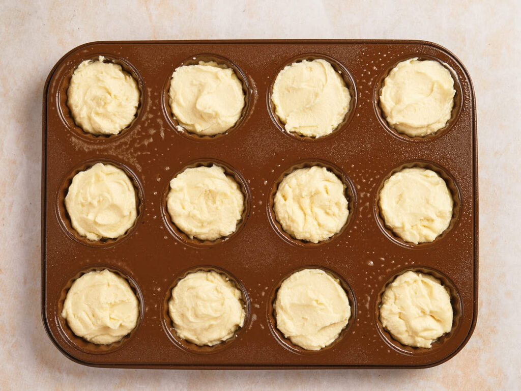 A muffin tin filled with unbaked batter, ready to be placed in the oven.