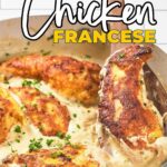 Golden-brown chicken breasts simmer in a creamy sauce, garnished with chopped parsley, in a skillet.