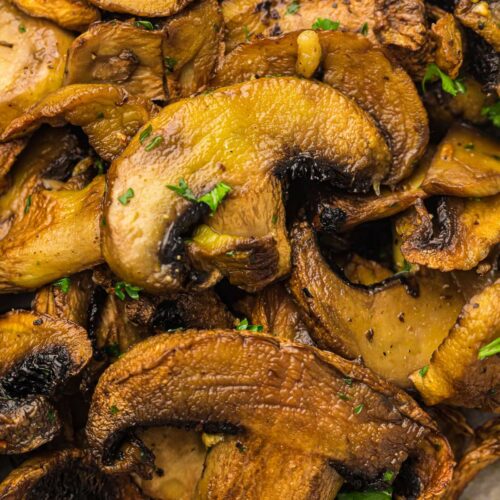 Close-up of sautéed mushrooms garnished with chopped parsley.