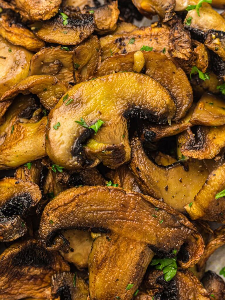 Close-up of sautéed mushrooms garnished with chopped parsley.
