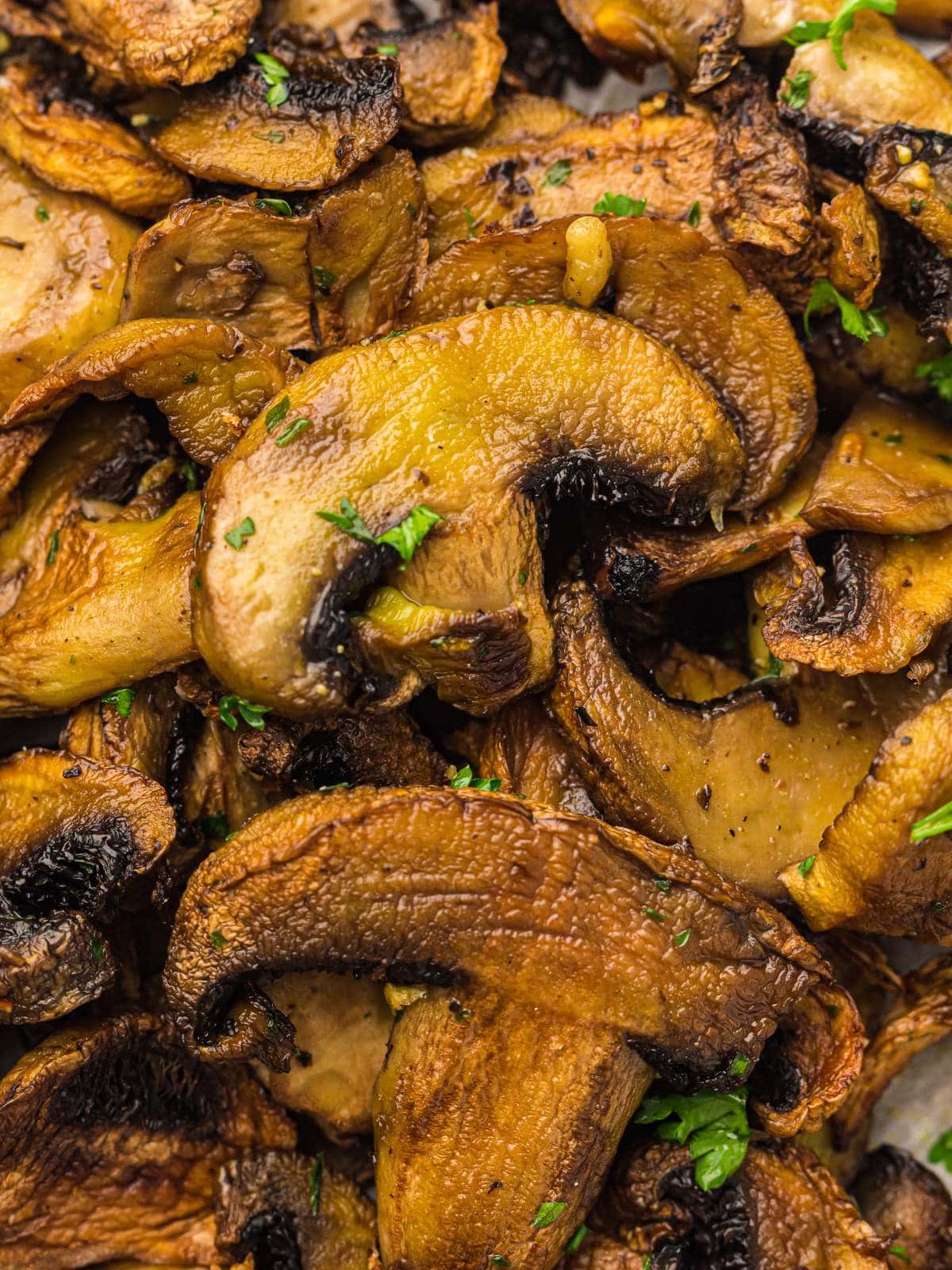 Close-up of sautéed mushrooms garnished with chopped parsley.