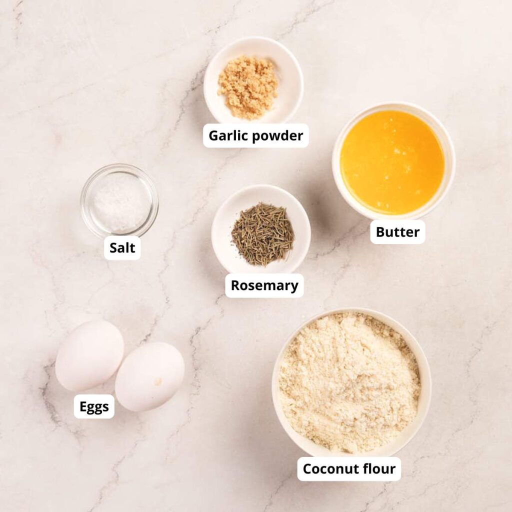 Seven labeled ingredients—garlic powder, salt, eggs, rosemary, butter, and coconut flour.