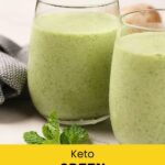 Two glasses of green smoothie on a light surface, garnished with mint leaves, with a gray towel in the background.