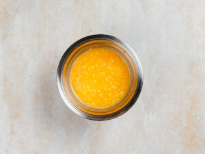 A stainless steel bowl containing whisked eggs.
